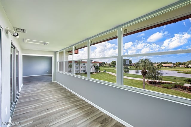 unfurnished sunroom featuring a water view