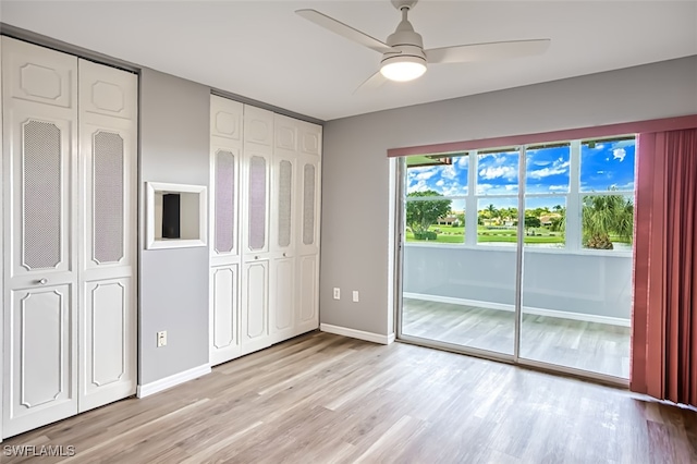 unfurnished bedroom with two closets, ceiling fan, and light hardwood / wood-style floors