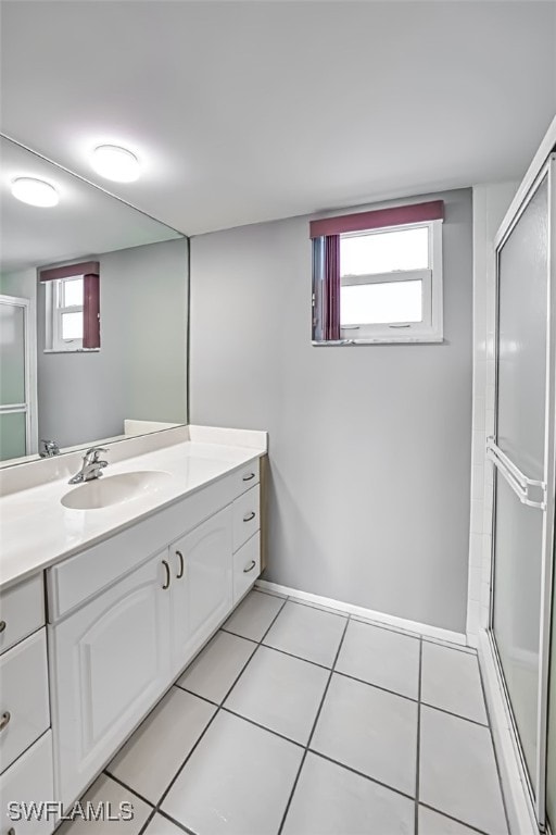 bathroom featuring vanity, a shower with shower door, and a wealth of natural light