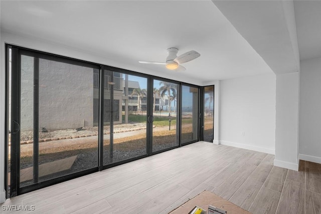 empty room with expansive windows and ceiling fan