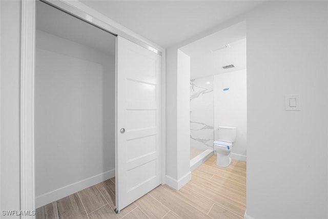 bathroom featuring toilet and tiled shower