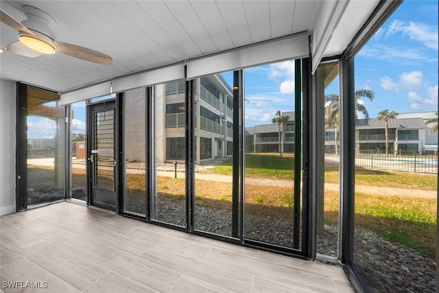 unfurnished sunroom with ceiling fan and a healthy amount of sunlight