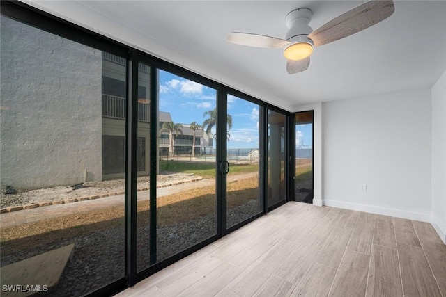 empty room with floor to ceiling windows and ceiling fan