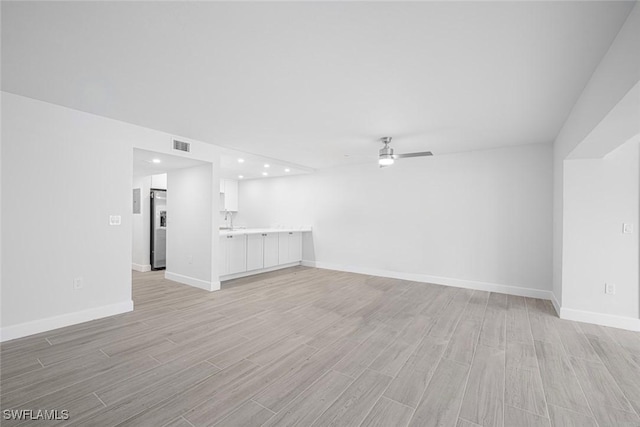 unfurnished living room featuring ceiling fan