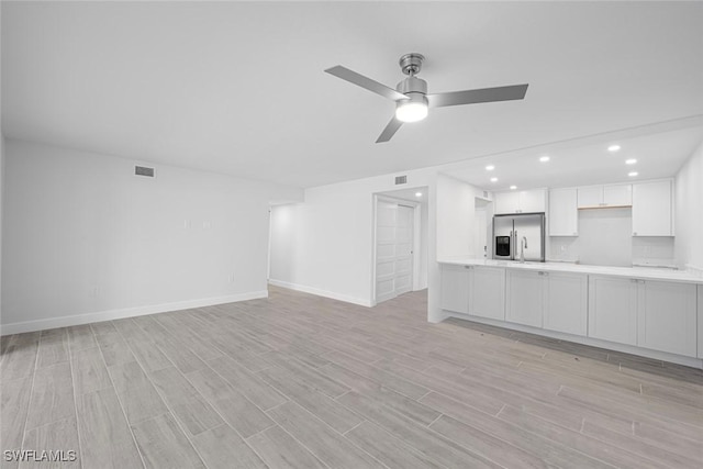 unfurnished living room featuring ceiling fan