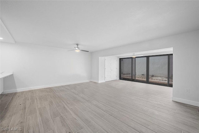 spare room with ceiling fan and light wood-type flooring