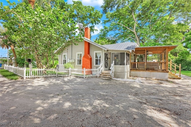 view of front facade featuring a wooden deck and a sunroom