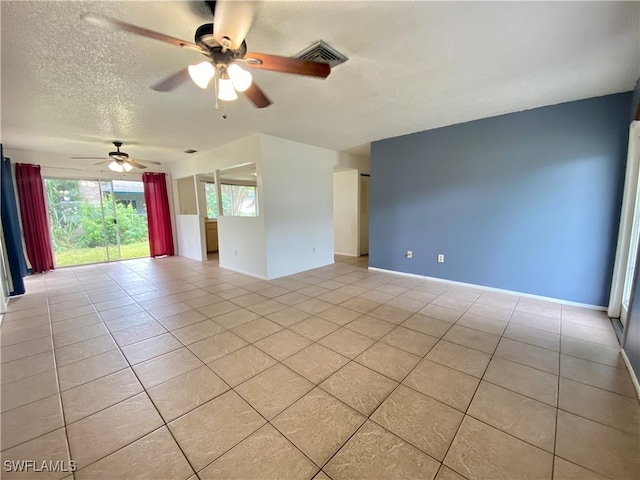 unfurnished room with a textured ceiling, ceiling fan, and light tile patterned floors