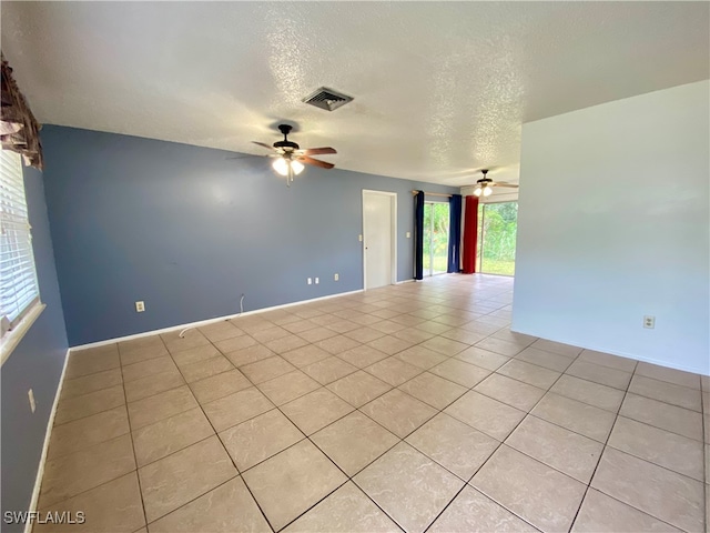 tiled empty room featuring ceiling fan and a textured ceiling