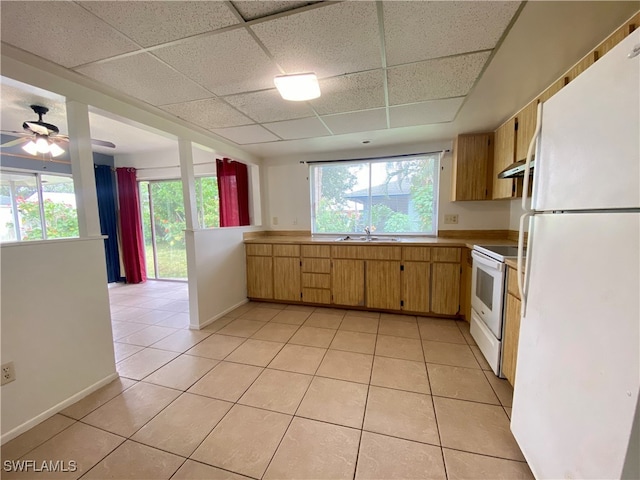 kitchen with a drop ceiling, white appliances, light tile patterned floors, and plenty of natural light