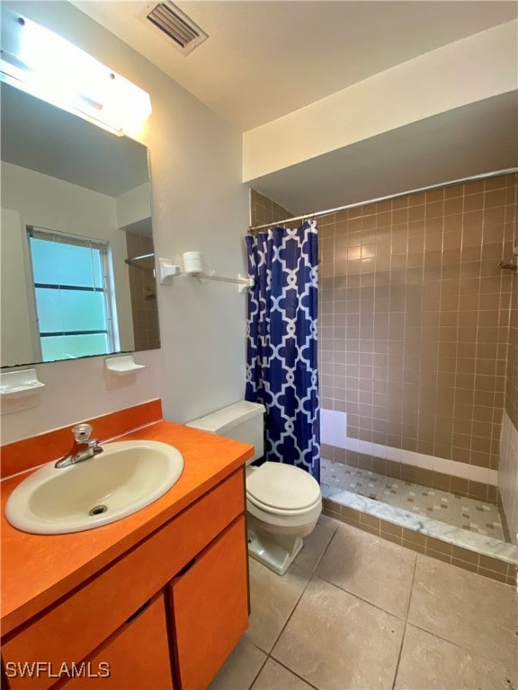 bathroom featuring toilet, a shower with shower curtain, vanity, and tile patterned floors