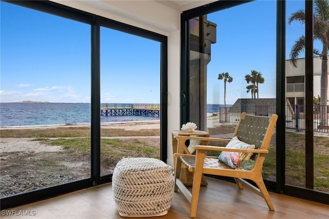 sunroom / solarium with a view of the beach and a water view