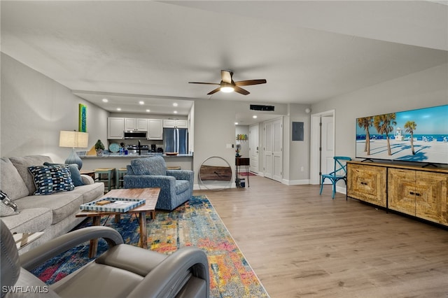 living room featuring ceiling fan and light hardwood / wood-style floors