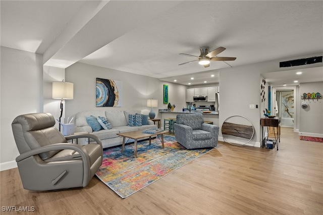 living room with ceiling fan and light hardwood / wood-style floors