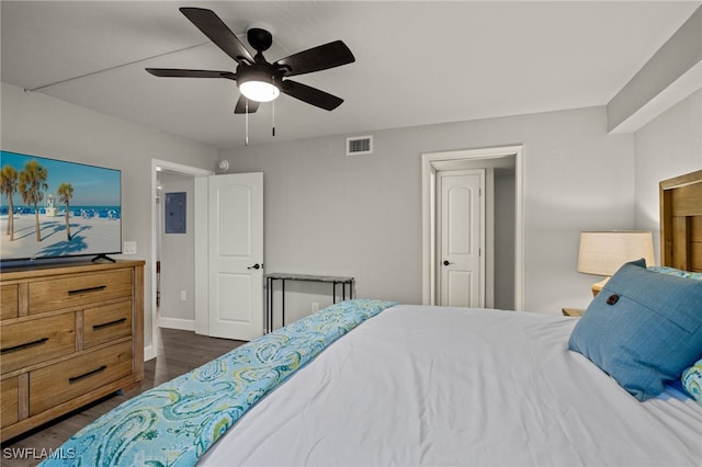 bedroom featuring electric panel, ceiling fan, and dark hardwood / wood-style flooring