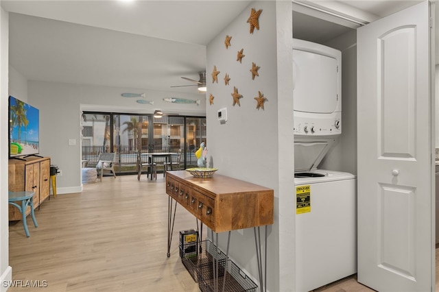 laundry room featuring ceiling fan, light hardwood / wood-style floors, and stacked washer / dryer