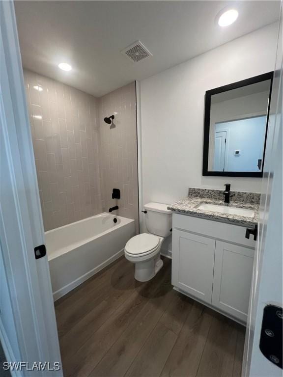 full bathroom with vanity, wood-type flooring, toilet, and tiled shower / bath