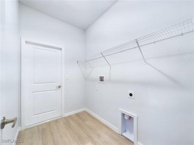 clothes washing area with hookup for an electric dryer, light wood-type flooring, and washer hookup