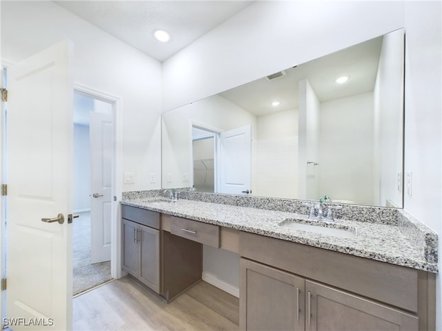 bathroom with hardwood / wood-style flooring and double sink vanity