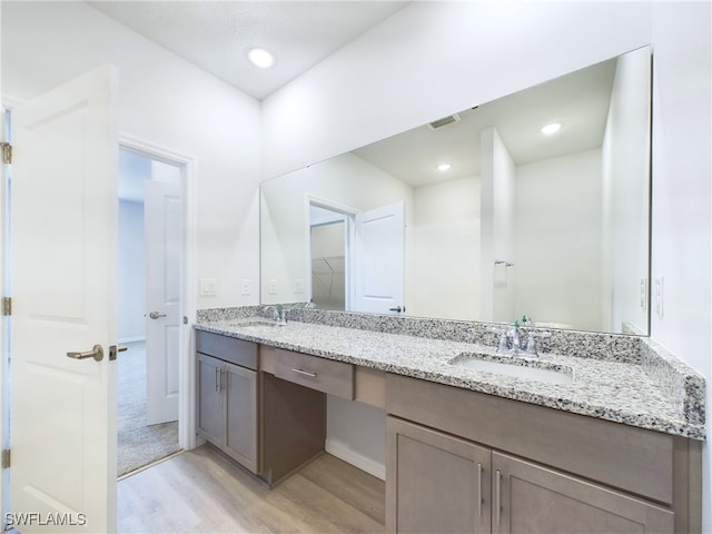 1057 Presque Isle Dr, Port Charlotte, FL 33952 - full bathroom featuring double vanity, visible vents, wood finished floors, and a sink
