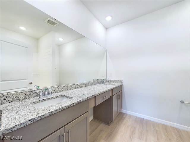 bathroom featuring wood-type flooring and double vanity