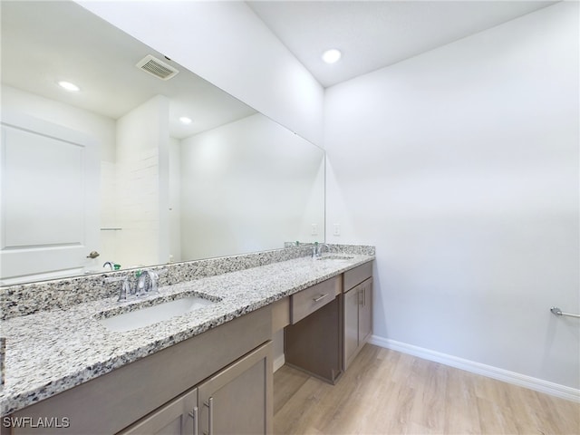 1057 Presque Isle Dr, Port Charlotte, FL 33952 - bathroom with baseboards, a sink, visible vents, double vanity, and wood finished floors