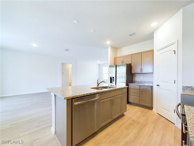 1057 Presque Isle Dr, Port Charlotte, FL 33952 - kitchen featuring an island with sink, a sink, appliances with stainless steel finishes, visible vents, and light wood-style floors