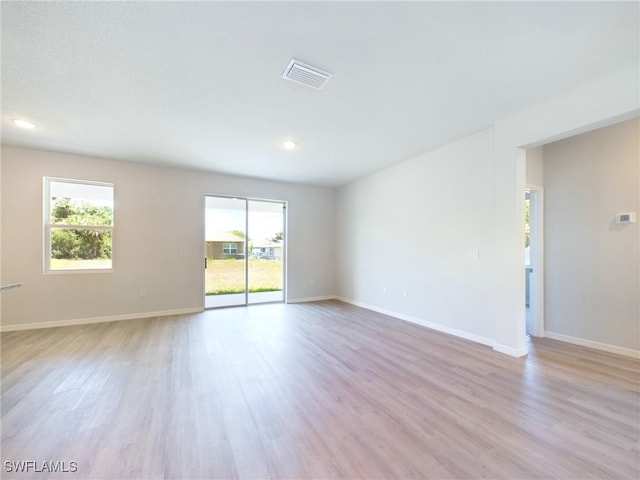 empty room featuring a wealth of natural light and light hardwood / wood-style flooring