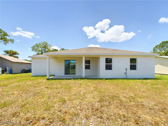 rear view of property featuring a lawn and a patio