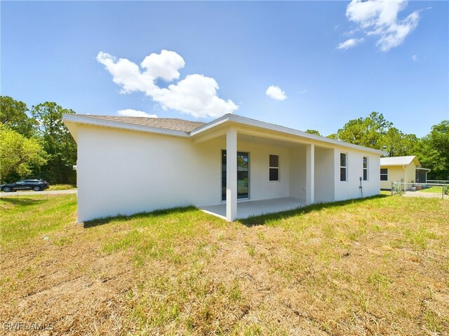 1057 Presque Isle Dr, Port Charlotte, FL 33952 - back of property featuring fence, stucco siding, a yard, and a patio area
