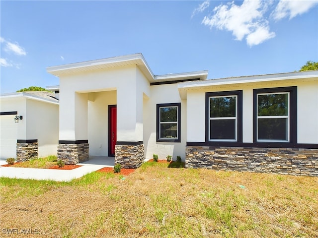 1057 Presque Isle Dr, Port Charlotte, FL 33952 - view of front facade with stone siding, an attached garage, and stucco siding