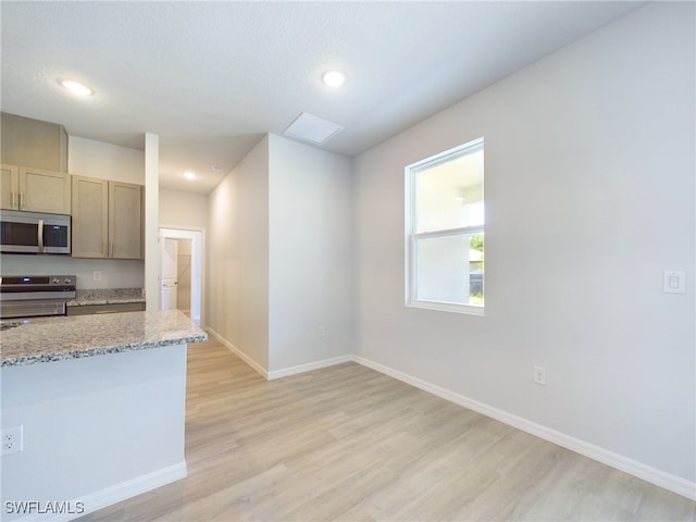 kitchen featuring light hardwood / wood-style floors, range, and light stone countertops