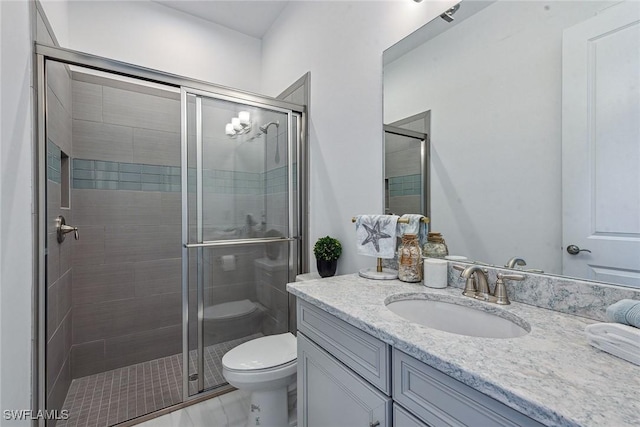 full bathroom featuring toilet, a stall shower, and vanity