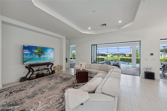 living area with a tray ceiling, light tile patterned floors, recessed lighting, visible vents, and a sunroom