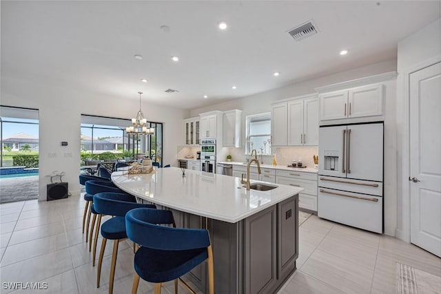 kitchen featuring a large island, tasteful backsplash, an inviting chandelier, appliances with stainless steel finishes, and white cabinets