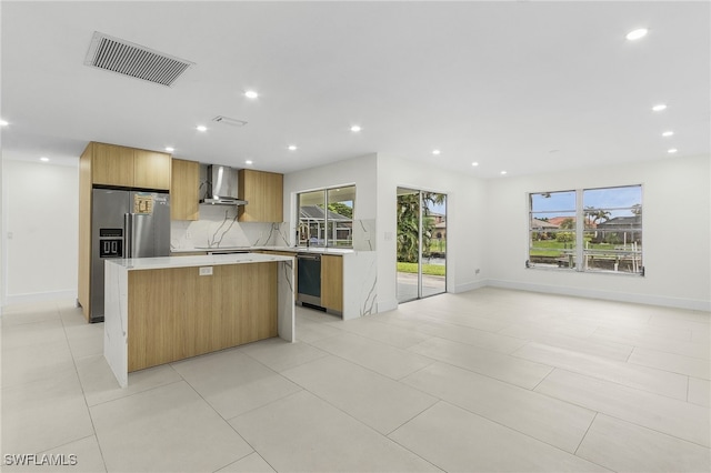 kitchen with dishwasher, decorative backsplash, wall chimney exhaust hood, a kitchen island, and light tile patterned flooring