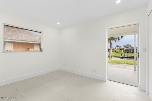 tiled spare room featuring a healthy amount of sunlight