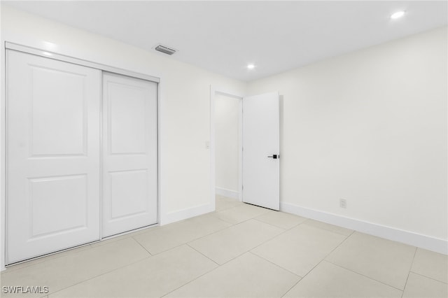 unfurnished bedroom featuring a closet and light tile patterned flooring