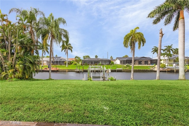 dock area with glass enclosure, a lawn, and a water view