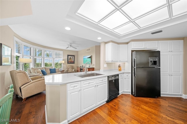 kitchen featuring white cabinets, sink, black appliances, kitchen peninsula, and dark wood-type flooring