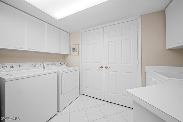 washroom featuring washer and clothes dryer, light tile patterned floors, cabinets, and sink