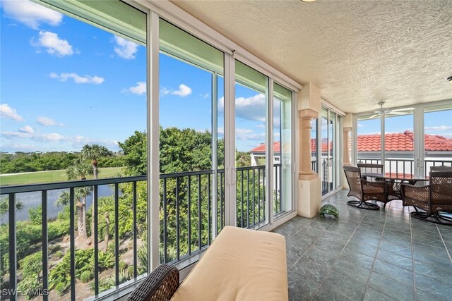 sunroom / solarium with a healthy amount of sunlight and ceiling fan