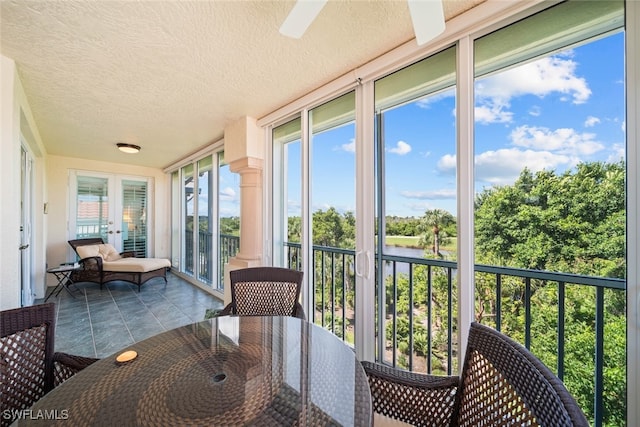 sunroom / solarium featuring ceiling fan and french doors