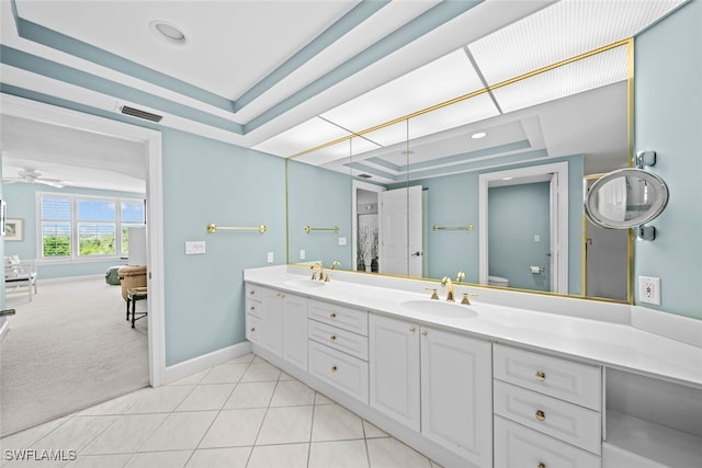 bathroom featuring vanity, a raised ceiling, toilet, tile patterned floors, and ceiling fan