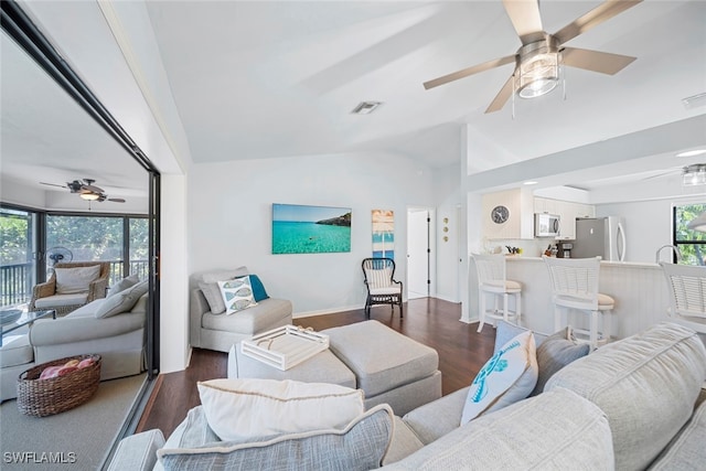 living room with ceiling fan, vaulted ceiling, and dark hardwood / wood-style flooring