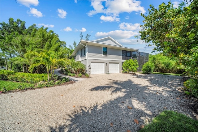 view of property exterior featuring a garage and a lanai