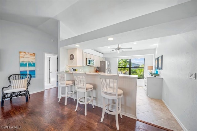 1610 Sabal Sands Rd, Sanibel, FL 33957 - kitchen featuring a peninsula, stainless steel appliances, light wood-type flooring, a breakfast bar area, and light countertops