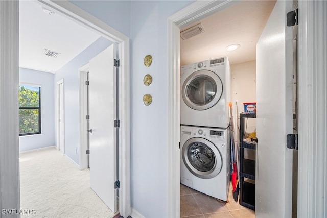 washroom featuring tile patterned floors and stacked washing maching and dryer