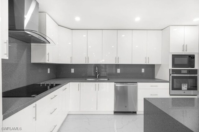 kitchen featuring white cabinets, wall chimney exhaust hood, modern cabinets, black appliances, and a sink