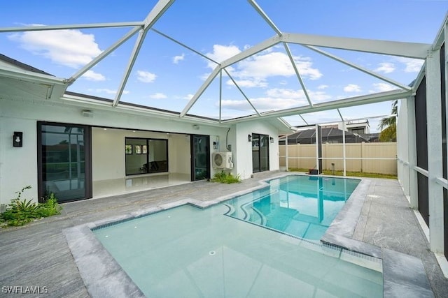 view of swimming pool with glass enclosure, fence, a fenced in pool, and a patio